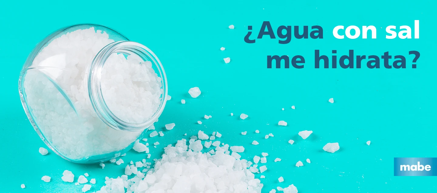 Frasco de vidrio derramando sal gruesa sobre una superficie azul turquesa, con la pregunta ¿Agua con sal me hidrata? y el logotipo de mabe en la esquina inferior derecha