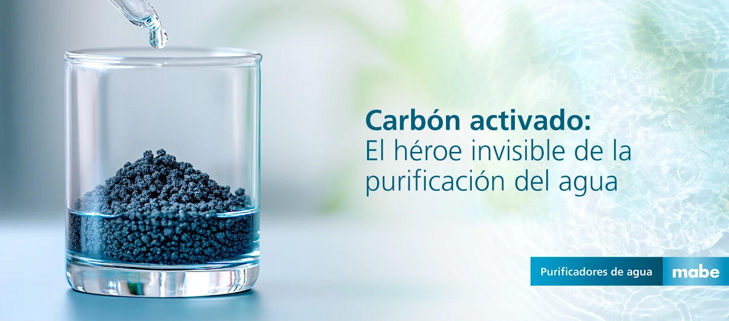 Vaso de vidrio con carbón activado granulado y una gota cayendo, acompañado del texto 'Carbón activado: El héroe invisible de la purificación del agua'. Campaña de purificadores de agua mabe